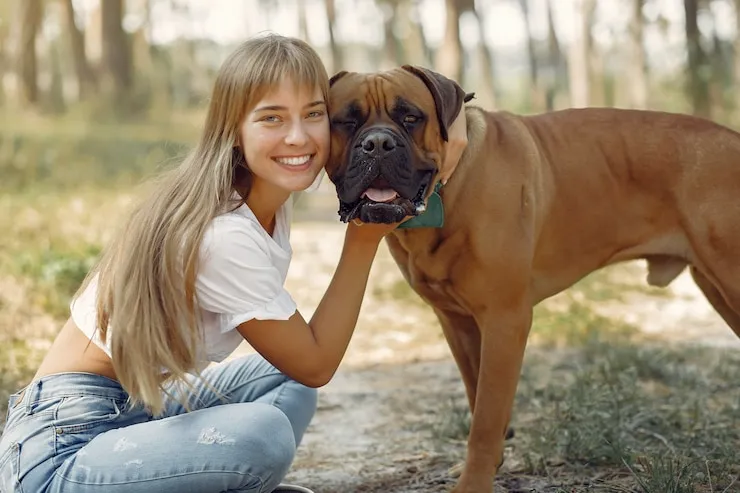 woman playing with dog in summer
